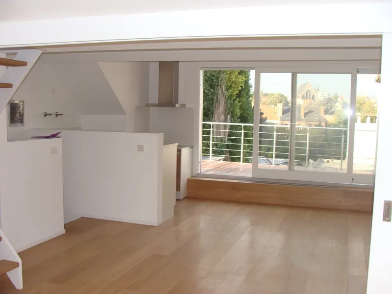 Completed top floor with an oak floor, a white kitchen unit and a sliding door onto the terrace.