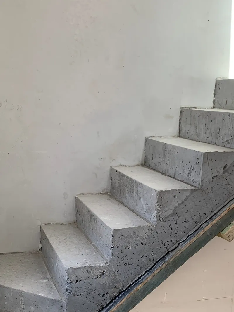 Raw cast concrete staircase with cantilevered treads.
