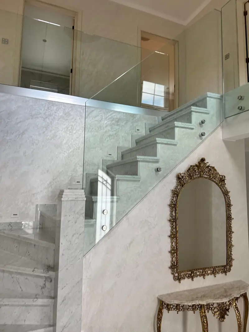 Finished marble staircase with glass balustrade on stainless point fixings.